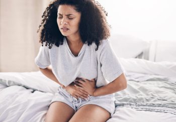 Abdomen pain, period and black woman in bed with abdominal cramps, menstruation and stomach ache. H.